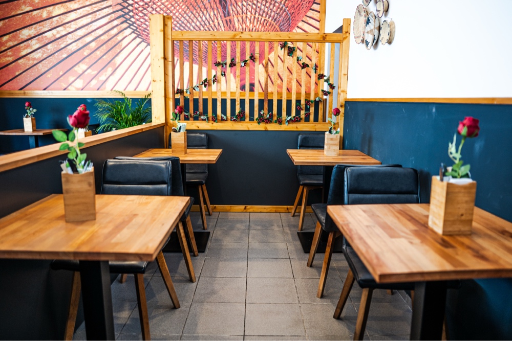 Booth seating with navy walls and wood tables